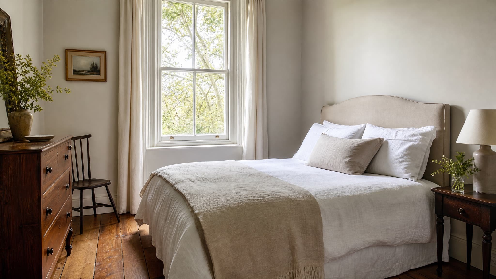 A calm, naturally lit bedroom dressed in linen